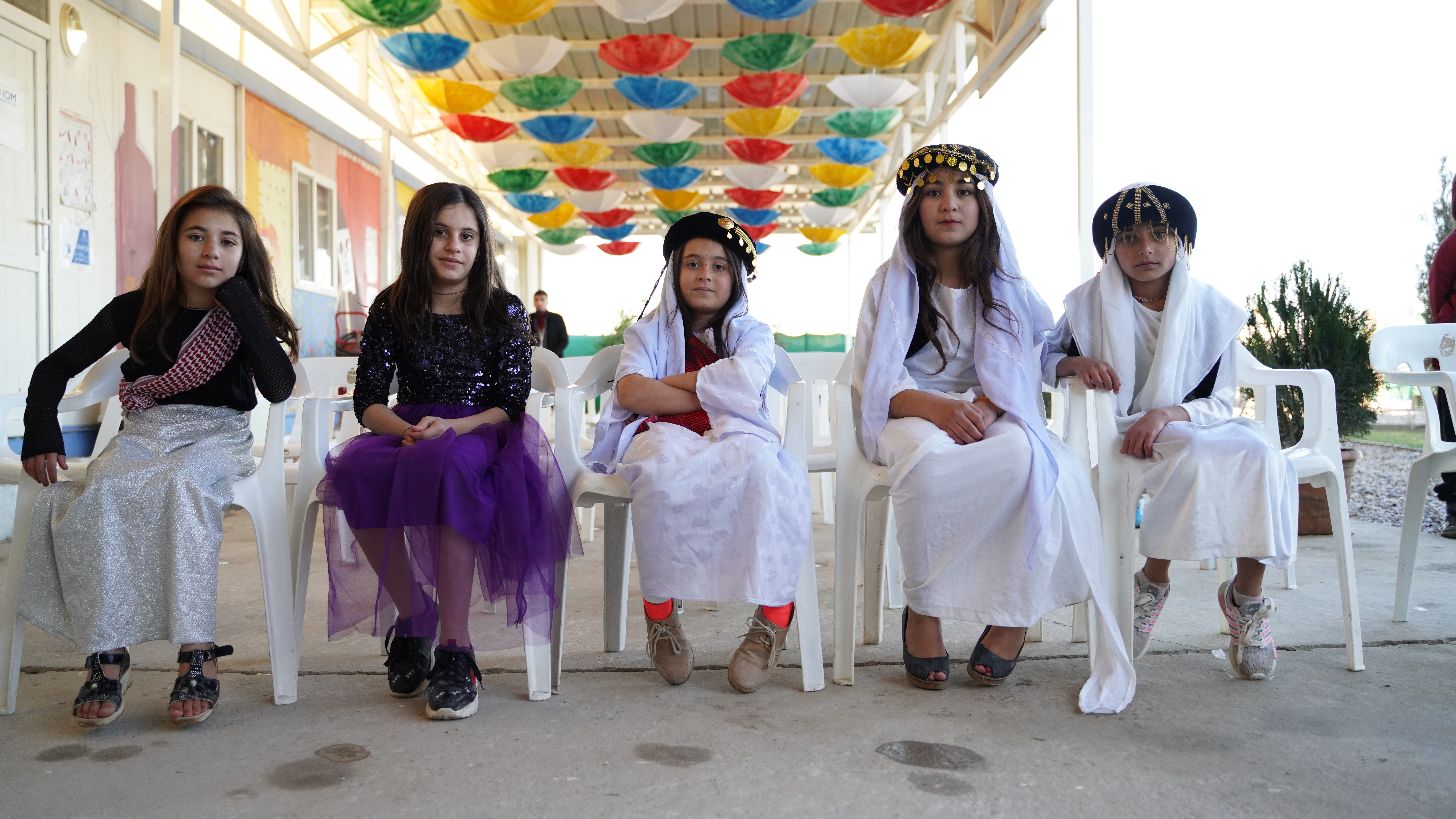 Yezidi children in their traditional dresses prepare to perform a folk dance celebrating their culture and heritage at an IOM-supported event in Sharya camp, Duhok in northern Iraq. 