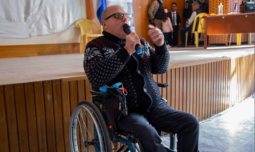 A man in a wheelchair addressing people
